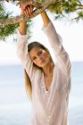 Portrait of young woman standing under tree — Stock Photo