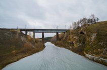 Paysage avec pont ferroviaire sur rivière gelée, Kislokan, Evenk, Russie — Photo de stock