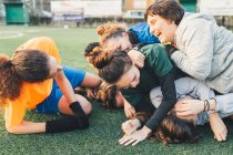 Football players jubilant and hugging on pitch — Stock Photo