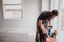 Padre e figlia miscelano cemento in secchio con miscelatore manuale — Foto stock