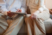 Seniorenpaar nutzt digitales Tablet zu Hause — Stockfoto