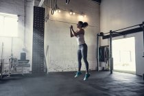 Женщина в спортзале прыгает в воздухе — стоковое фото