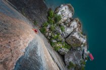 Hombre escalada en roca caliza, vista aérea, Ha Long Bay, Vietnam - foto de stock