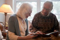 Senior couple looking in photo album — Stock Photo
