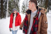 Jeune couple marchant dans la neige — Photo de stock