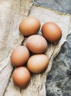 Primo piano vista di sei uova fresche marroni su un panno — Foto stock