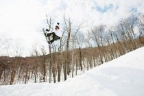 Vista di angolo basso del salto dello snowboarder a mezz'aria — Foto stock