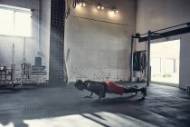 Homme dans la salle de gym faire pousser vers le haut — Photo de stock