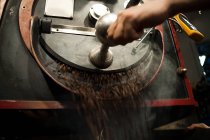 Закрыть кофейные бобы в кофейном гриле — стоковое фото