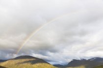 Rainbow over mountain landscape, Parc national de Jotunheimen, Lom, Oppland, Norvège — Photo de stock