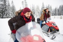 Giovani uomini a cavallo di motoslitte in inverno — Foto stock