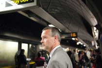 Homme d'affaires dans la station de métro détournant les yeux — Photo de stock
