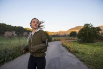 Молодая женщина бежит по сельской дороге — стоковое фото