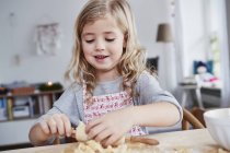 Молода дівчина розкачує тісто для печива — стокове фото