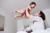 Mother holding baby daughter in air — Stock Photo