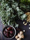 Still life of kale, dates, cashews and fresh ginger, overhead view — Stock Photo