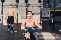 Man in gym using rowing machine — Stock Photo