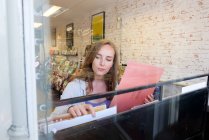 Jeune femme regardant des disques vinyle dans un magasin de disques — Photo de stock