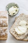 Ansicht von oben Laib Brot mit Butter geschnitten — Stockfoto