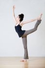 Vista lateral de la mujer practicando yoga en estudio - foto de stock