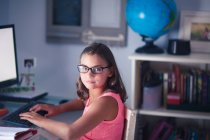 Retrato de menina em óculos usando computador — Fotografia de Stock