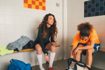 Football players on bench in changing room — Stock Photo