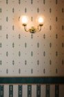 Wall lamp against patterned wallpaper — Stock Photo