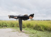 Seitenansicht einer jungen Touristin, die Yoga praktiziert, Okavango-Delta, Botswana, Afrika — Stockfoto