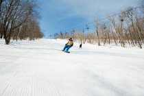 Двоє людей сноубордингу на снігу пелериною лижний схил — стокове фото