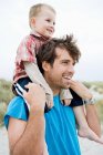 Young man carrying boy on shoulders — Stock Photo