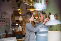 Female friends shopping in lighting shop — Stock Photo