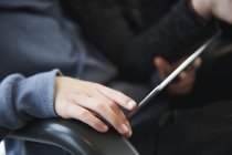 Cropped image of Child using digital tablet and sitting in chair — Stock Photo