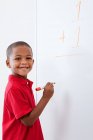 Portrait of Boy with sum on whiteboard — Stock Photo