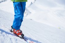 Avvicinamento delle gambe dello sciatore sulla neve — Foto stock