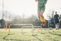 Футболіст стрибає через перешкоди — стокове фото