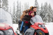 Young men riding snowmobile in winter — Stock Photo