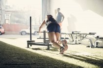Жінка в спортзалі використовує тренажери — стокове фото