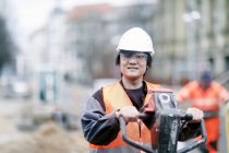 Jovem trabalhador da construção usando chapéu duro — Fotografia de Stock