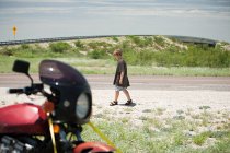 Хлопчик ходить повз мотоцикл — стокове фото