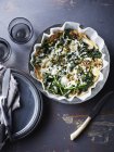 Still life with bowl of spinach feta mushroom frittata, overhead view — Stock Photo