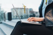 Side view of business woman using laptop outdoors — стоковое фото