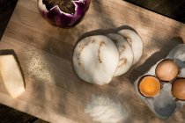Ovos, queijo e fatias de berinjela em tábua de madeira — Fotografia de Stock