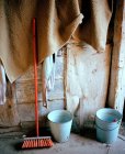 Vassoura e baldes em estábulo — Fotografia de Stock
