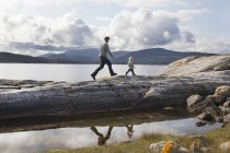 Man and son walking on fjord rock formation, Aure, More og Romsdal, Norvegia — Foto stock