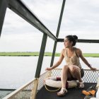 Asian Young female tourist in tour boat on Chobe River, Botswana, Africa — Stock Photo
