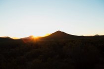 Sol sobre montañas oscuras, Sudáfrica - foto de stock
