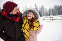 Young couple walking in snow — Stock Photo