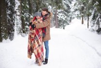 Jeune couple câlin dans la neige — Photo de stock