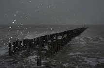 Paisaje marino con nieve en el rompeolas, Domburg, Zelanda, Países Bajos - foto de stock