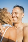 Casal maduro em swimwear abraçando na praia — Fotografia de Stock